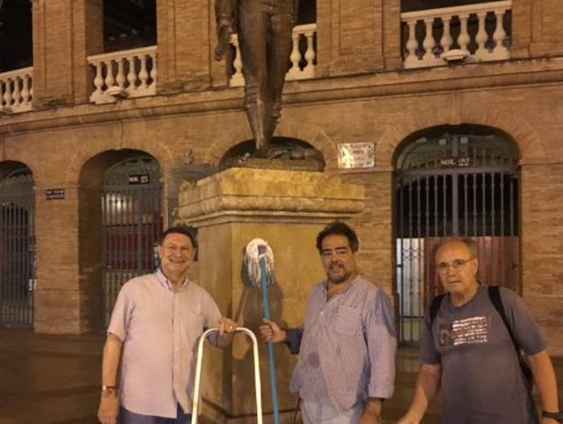 Ortiz, en el centro tras limpiar la estatua de Montoliu.Foto de Eduardo Osca