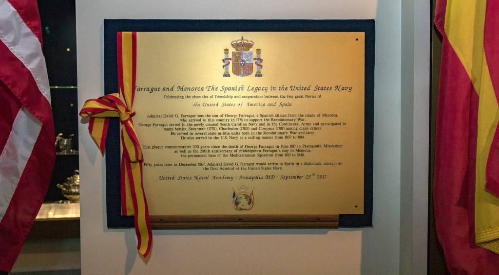 Placa después de su ubicación entre las banderas norteamericana y española.