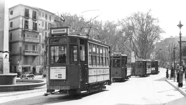 En la foto, cuatro tranvías en las Ramblas de Palma, junto a la famosa Fuente de las Tortugas; el tranvía que está en primer plano lleva delante un anuncio del vuelo regular de la BEA Palma-Londres