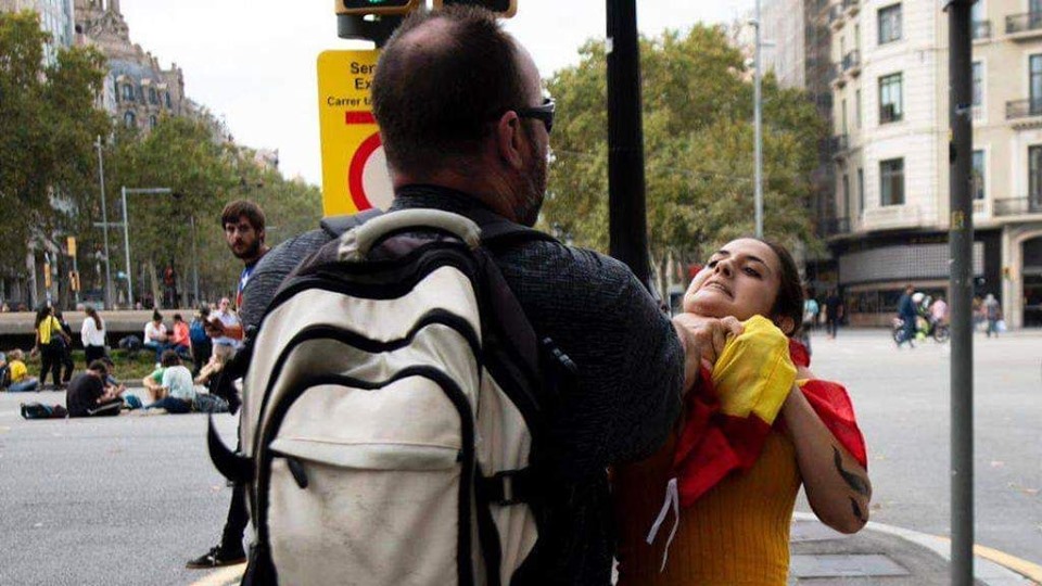 Momento en el que un fascista catalanista agrede a una mujer agarrándola del cuello por llevar una bandera de España.jpg