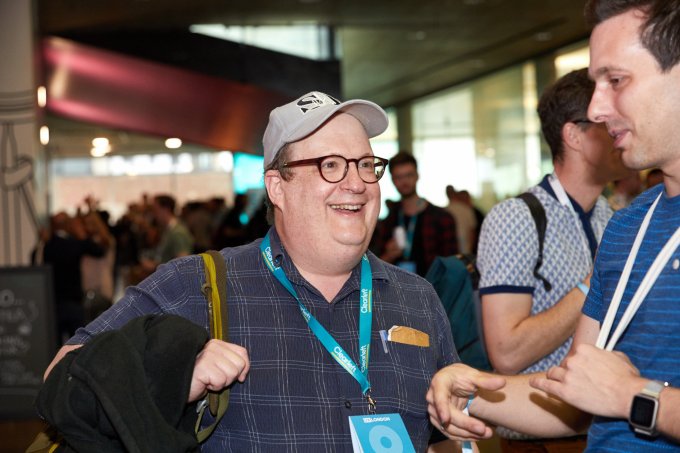 UX London Jared Spool talking to an attendee in the busy foyer