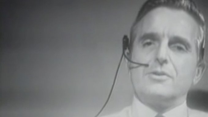 A screenshot from The Mother Of All Demos showing Douglas Engelbart wearing a headset.