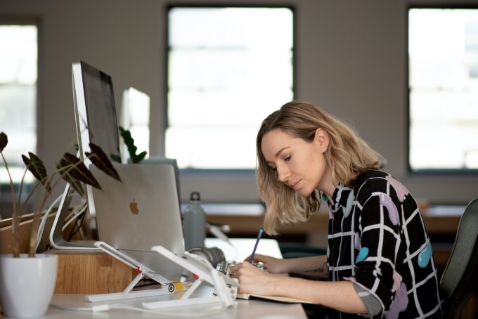 Cassie working at her desk in the Clearleft office in a colourful shirt
