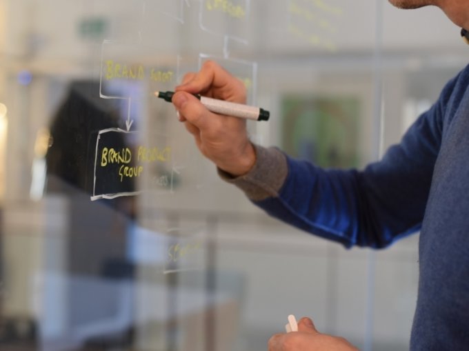 Man documenting the information architecture on glass