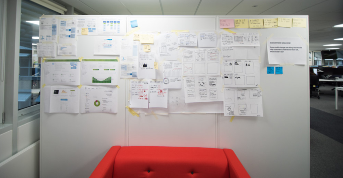 Display board covered in design sketches and customer journey maps