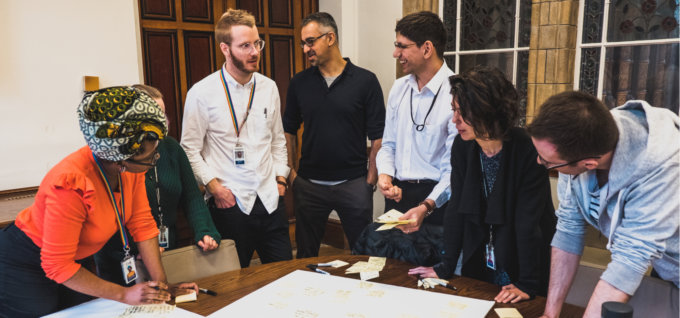 A grup huddled around a table at the discovery workshop