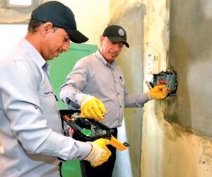 اثنان من الفريق التطوعي أثناء التأكد من محول كهربائي