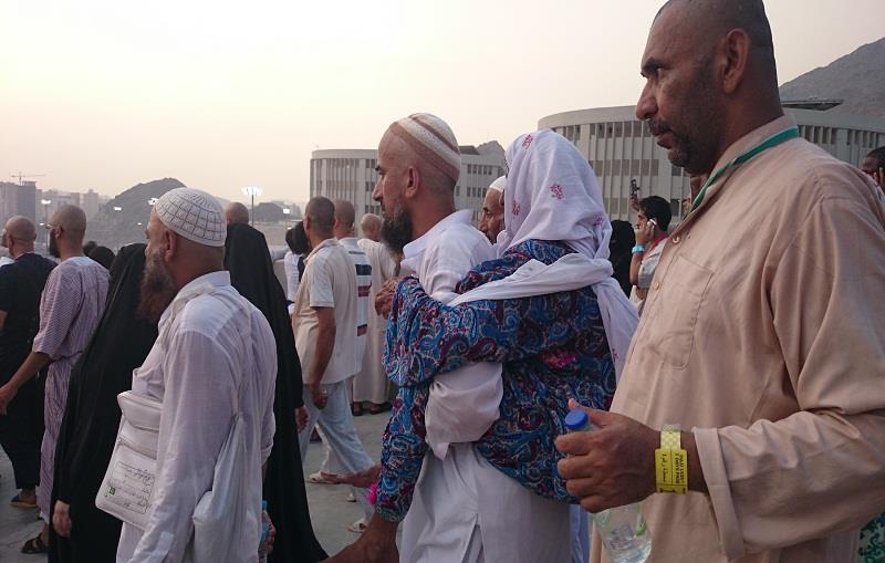 حاجّ باكستاني يحمل والدته المسنّة على ظهره
