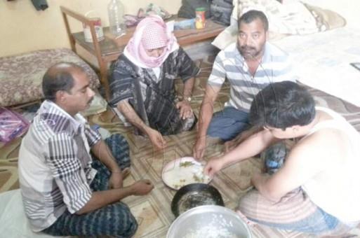 عمال أجانب يتناولون الطعام مع المواطن الخمسيني 