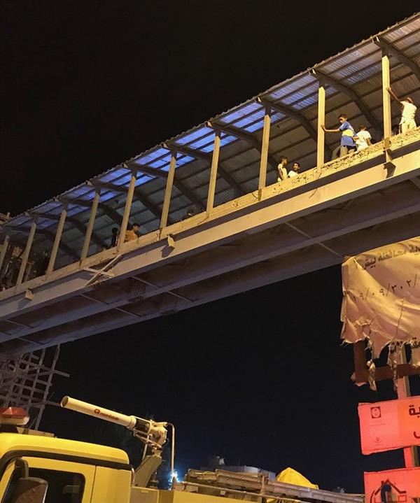 شاهد.. تجمهر عشرات الأطفال على جسر خَطِر تحت الإنشاء لمتابعة حادث انقلاب شاحنة في جازان