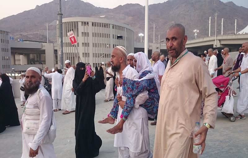 حاجّ باكستاني يحمل والدته المسنّة على ظهره