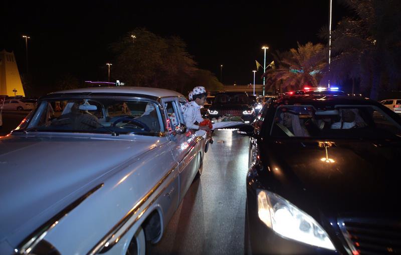 أمير القصيم يفتح نافذة سيارته ويقبل ورداً من طفل