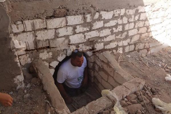 مسؤول مصري يفتح قبر والديه ويجلس معهما