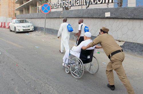 رجل أمن يعين حاجة على دفع عربة زوجها