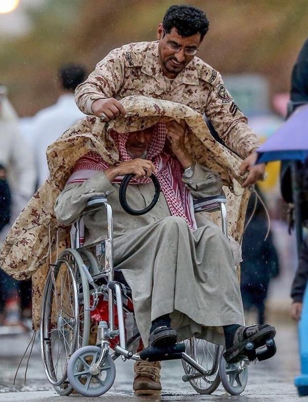 صورة لعسكري مع مسن تحت زخات المطر تلقى إشادة واسعة
