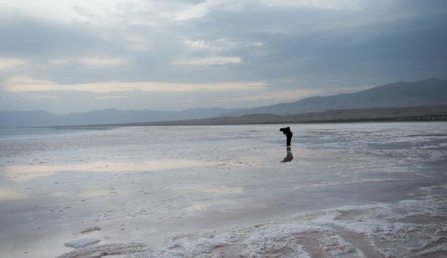 صورة لسيده تسير فوق سطح بقايا بحيرة اورومية