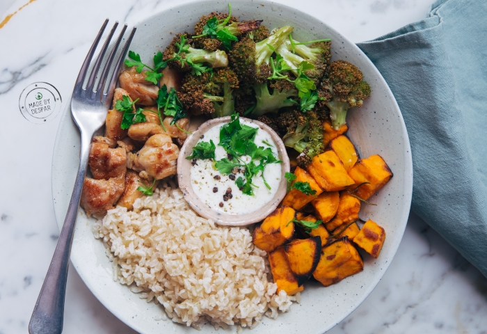 Bowl con riso integrale, zucca, broccoli arrosto, pollo e salsa allo yogurt