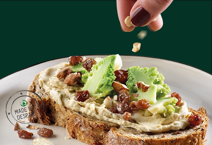 Bruschette con hummus di ceci, broccolo romanesco al limone, uvetta e mandorle