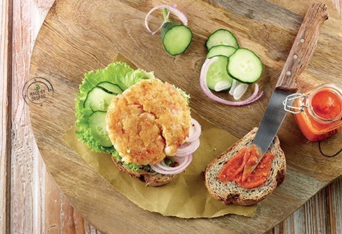 Burger di crostacei con lattuga, cetrioli, cipolla di Tropea e dressing al pomodoro