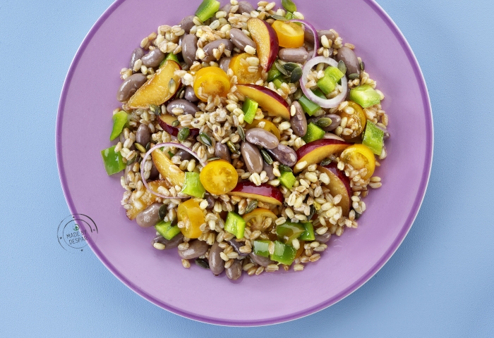 Insalata di farro con borlotti, prugne, peperoni, pomodorini e semi