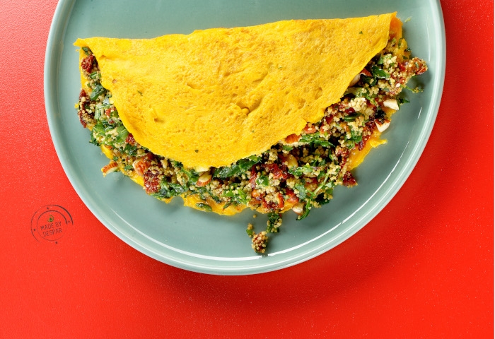 Omelette ripiena con cous cous, pomodori secchi, pesto di rucola e mandorle
