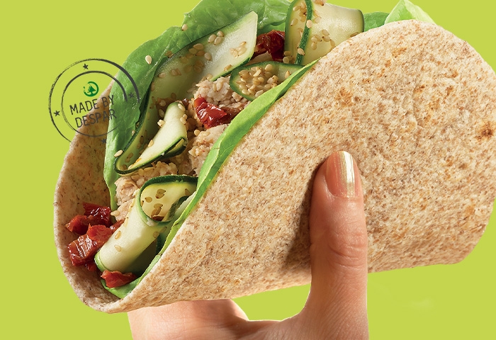 Piadina integrale con borlotti e zucchine marinate, pomodori secchi, lattuga e sesamo