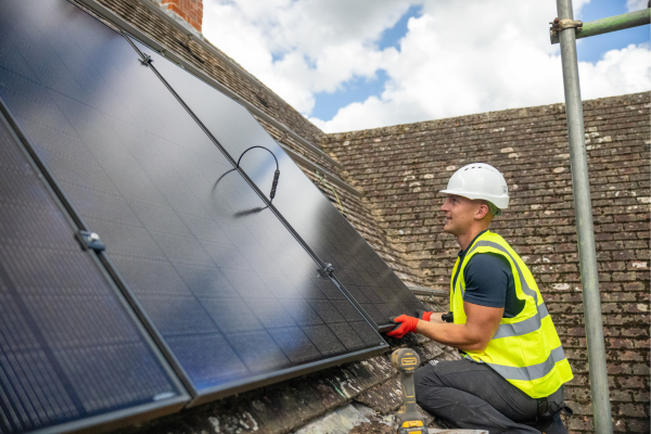 Person installing solar panels on a roof