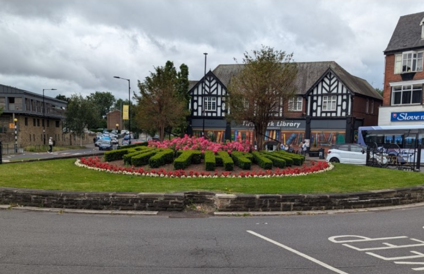 An image showing buildings and a road in front of a roundabout on Firth Park Road in north Sheffield 