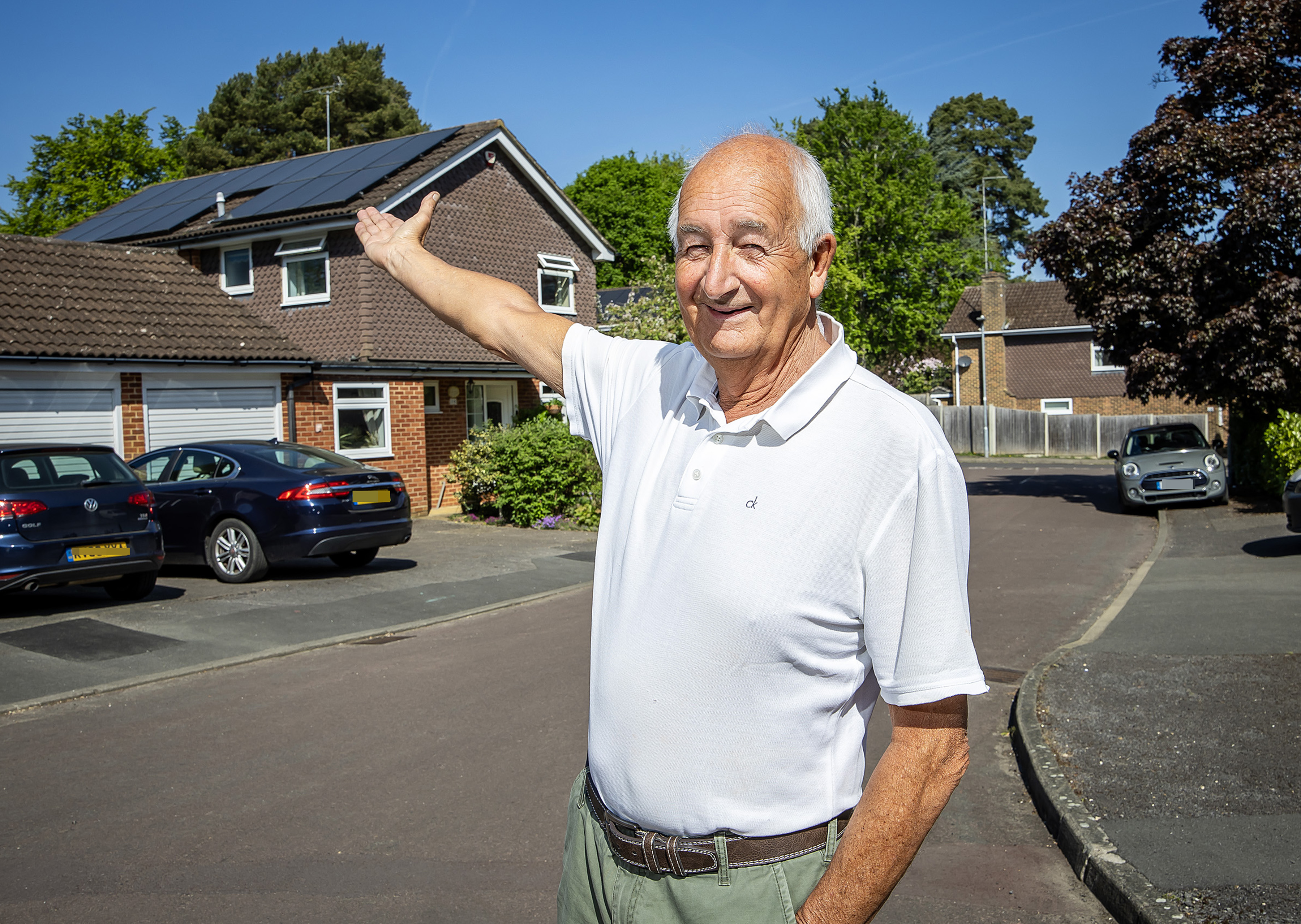 Man standing in front of home with solar panels on roof