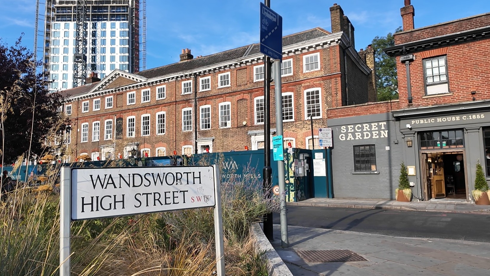 Wandsworth High Street sign beside historic brick buildings, a pub entrance and a modern tower