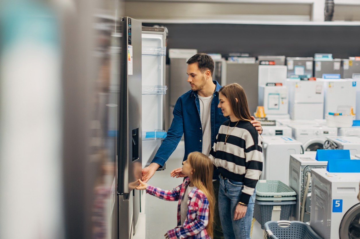Mum, dad and child shopping for a new fridge