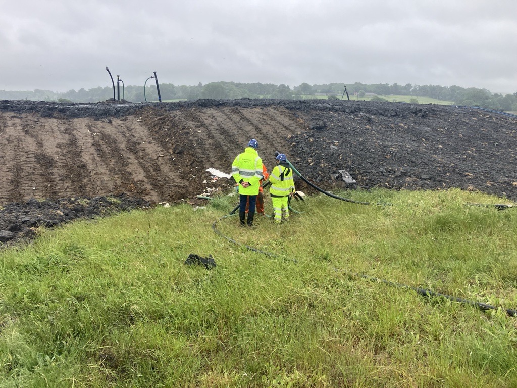 2 members of Environment Agency staff inspect the permanent capping works at the Lower Compton Hills waste site