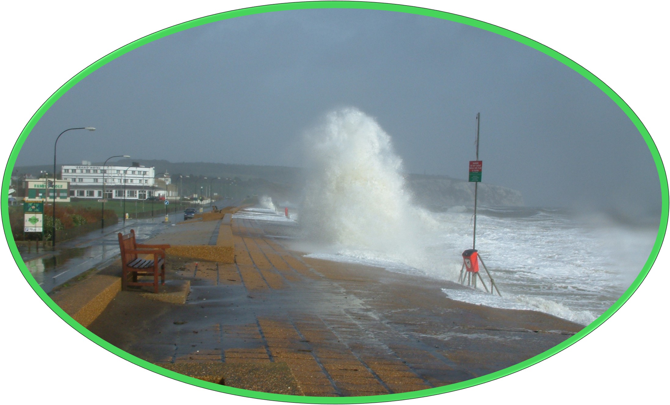 Image shows wave crashing into the promenade due to a storm.