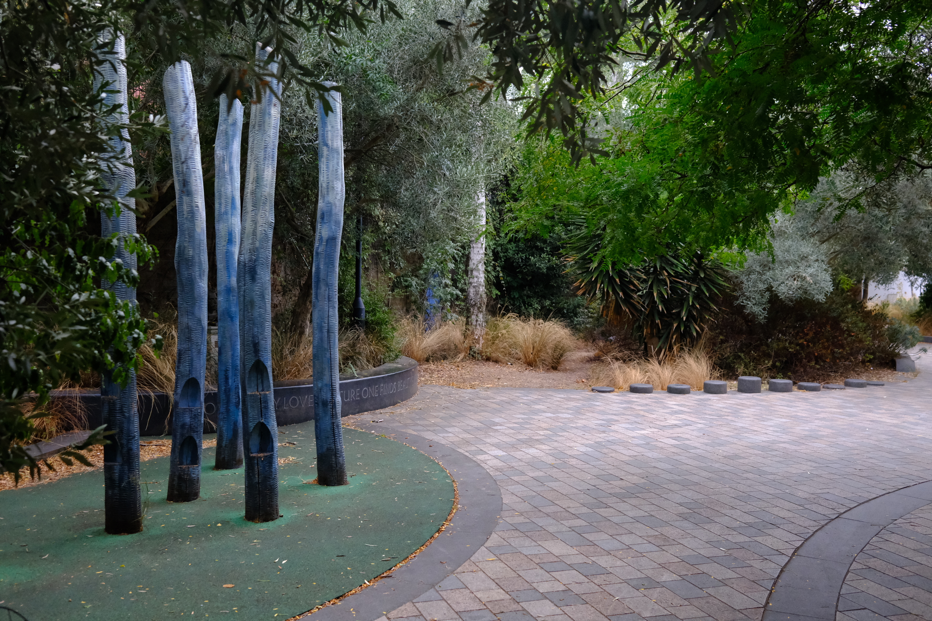 A street with nice paving, planting and wooden play features