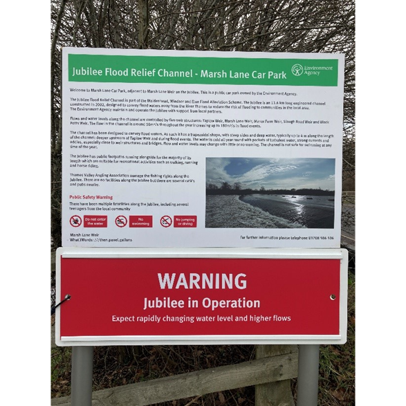 Photograph showing an example of a safety warning sign for the Jubilee Flood Relief Channel being in operation. This specific example is for Marsh Lane Car Park. The warning reads: "WARNING. Jubilee in Operation. Expect rapidly changing water level and higher flows".