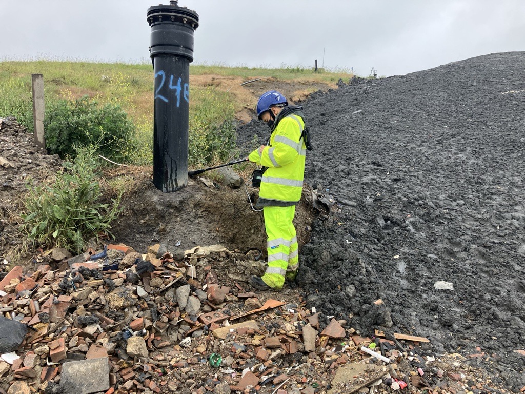 An Environment Agency officer uses monitoring equipment at the Lower Compton Hills waste site