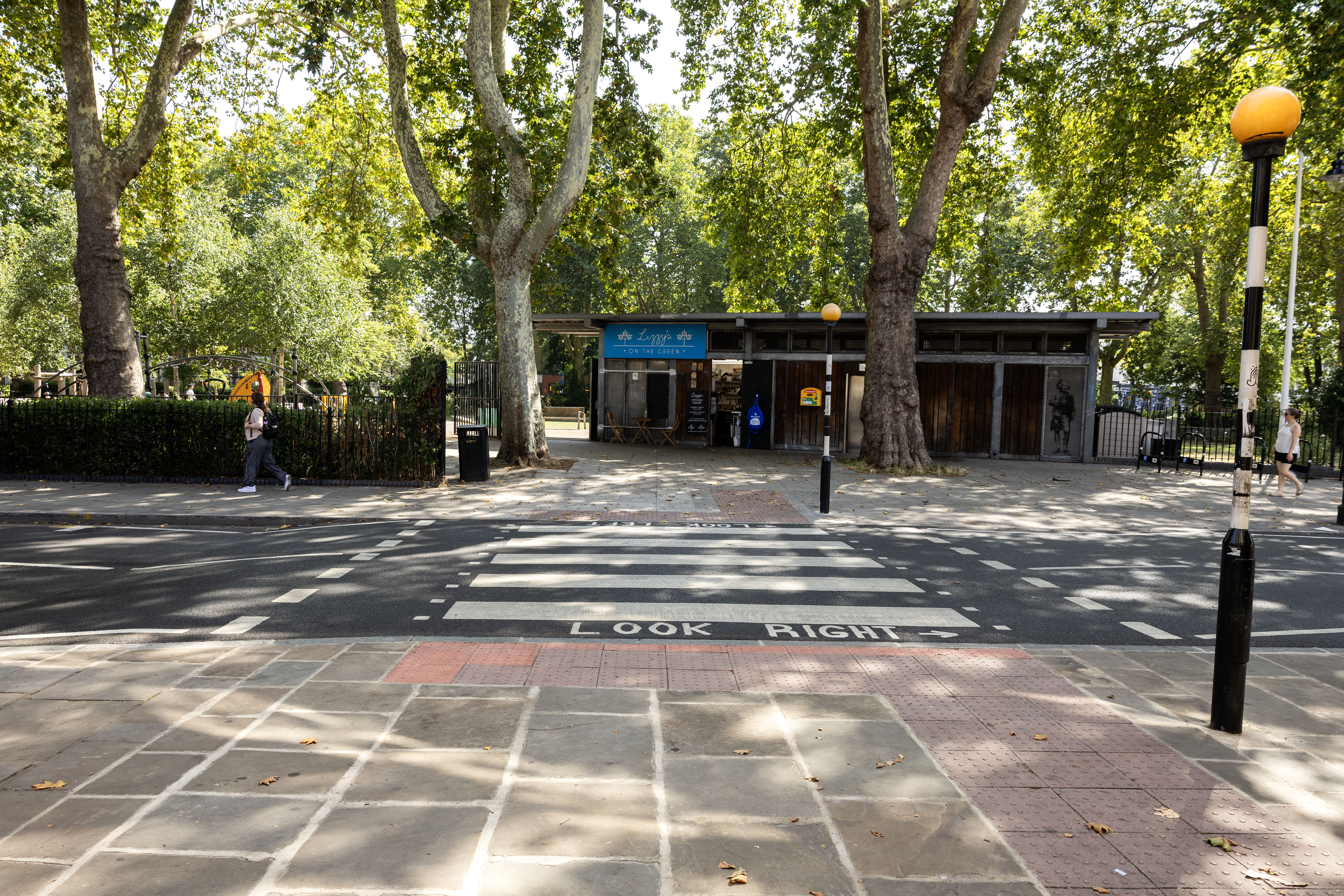 Zebra crossing across a road with trees in the background
