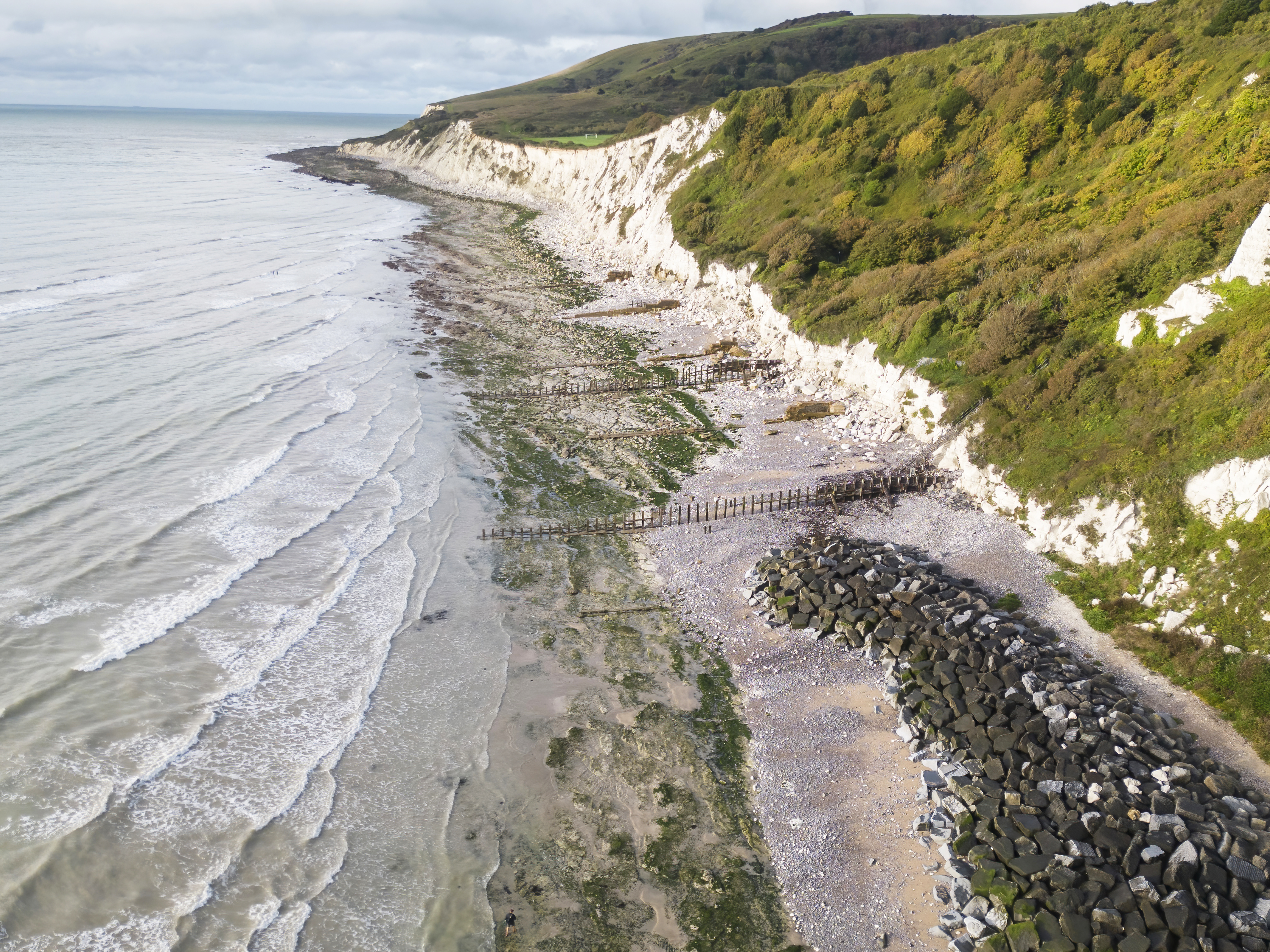 Aerial photo of the chalk cliffs at Holywell with the shingle beach, rocks, and the sea below. This image is used on the front cover of the Community Survey report.