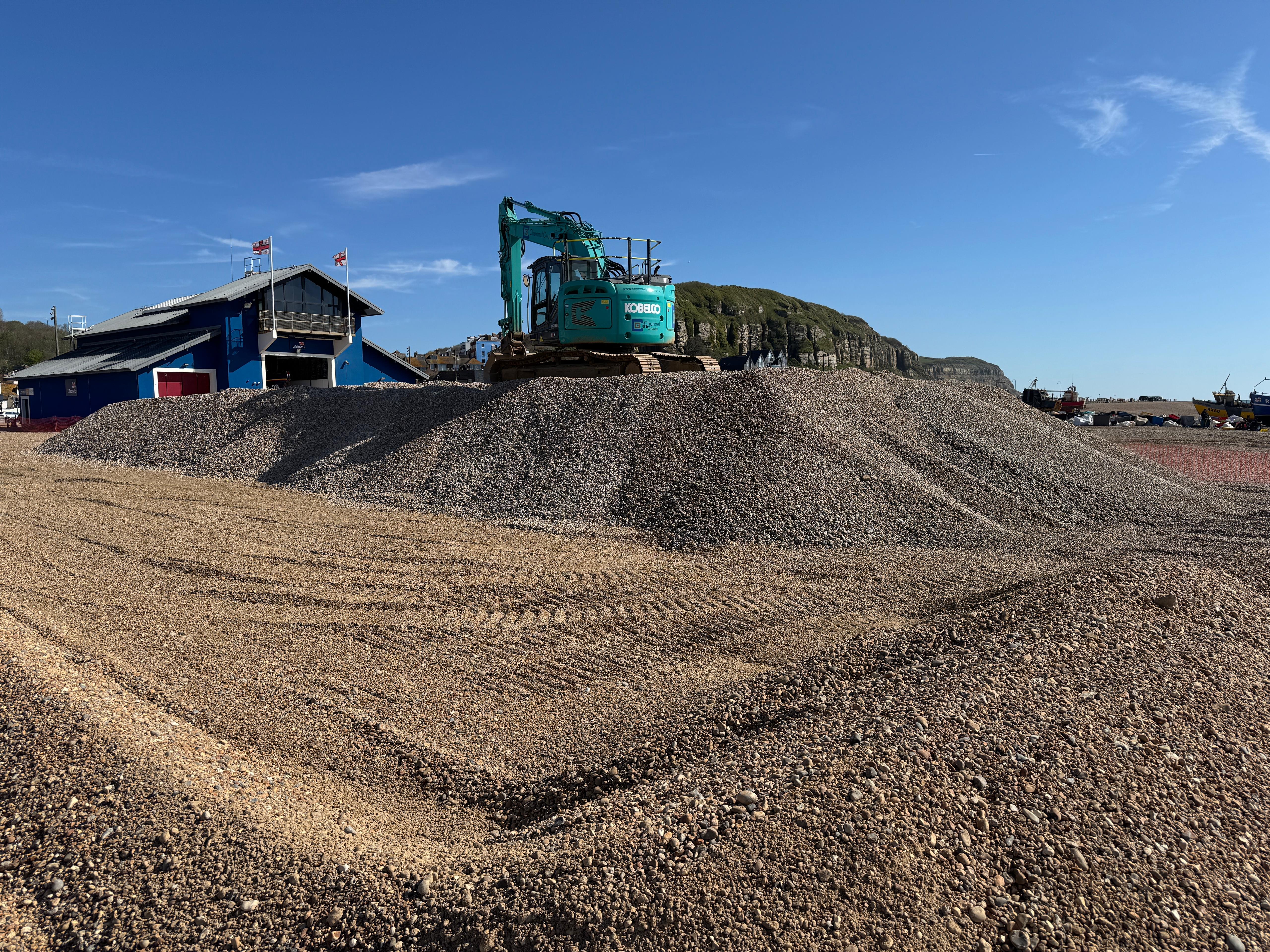 Using machinery to stockpile shingle in Hastings