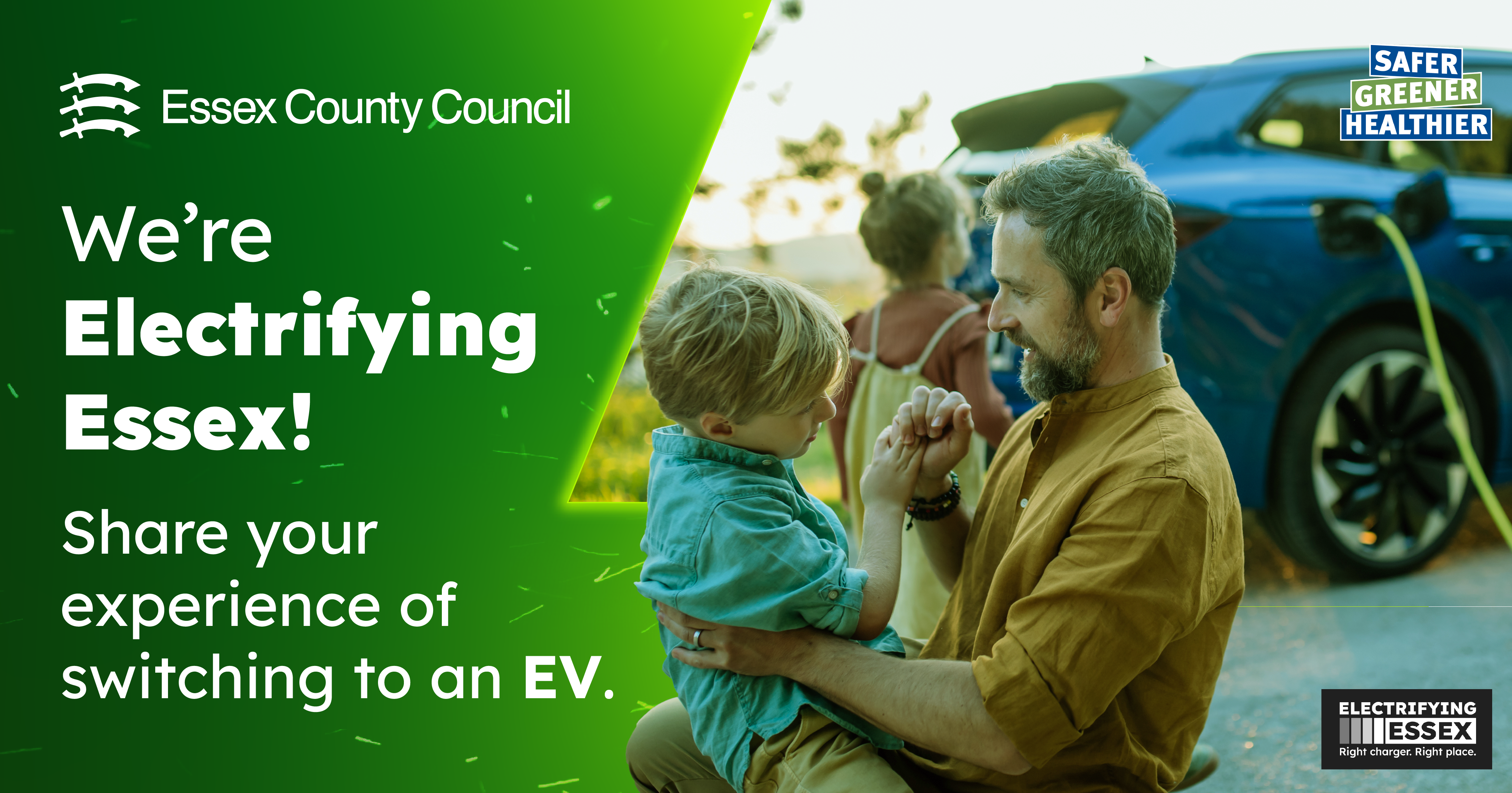 A man and his son knelt down talking in front of a blue EV, which is on charge. A young girl is also in the background