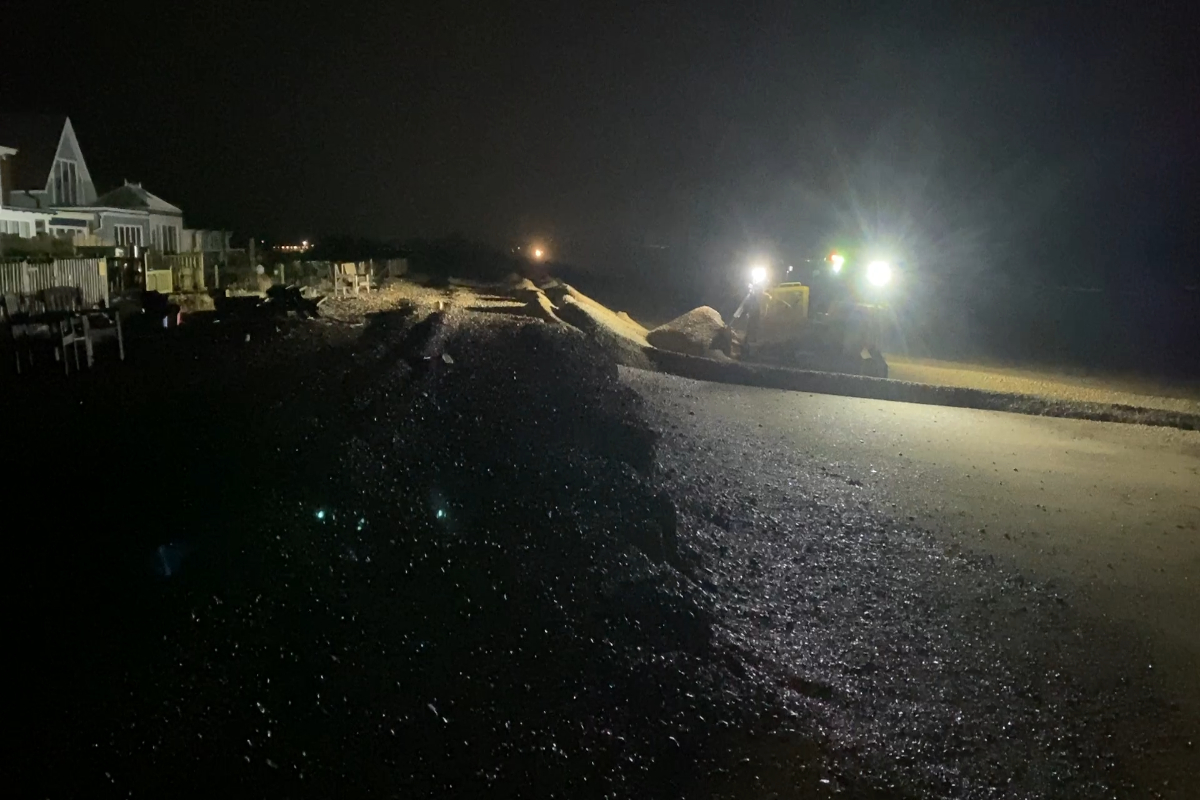 Machinery operating overnight to reprofile the beach during a storm event, helping maintain coastal defences and protect homes and infrastructure.