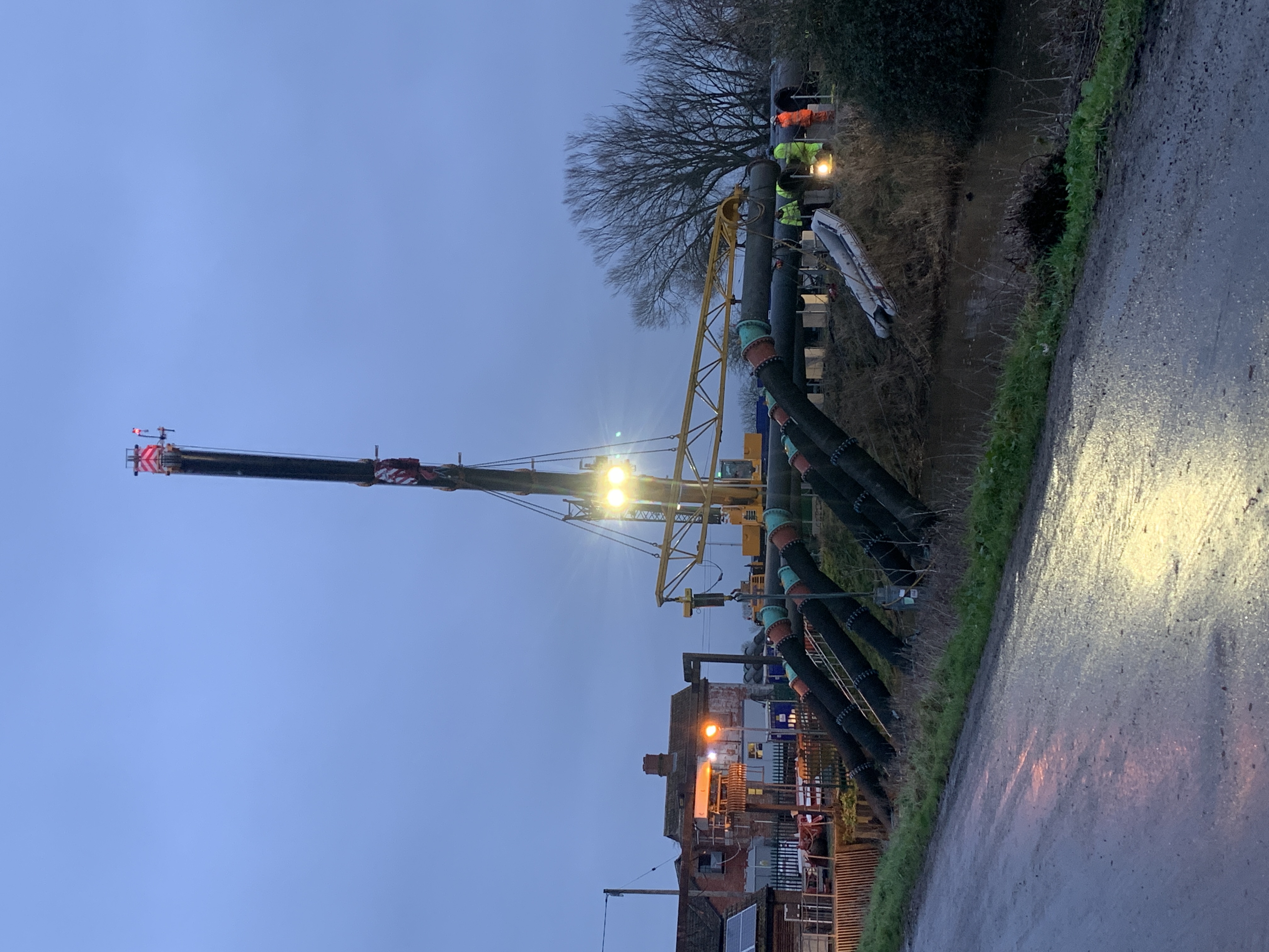 Image of crane putting large pumping equipment into the drain at the pumping station 