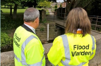 Two volunteer flood wardens looking at a river