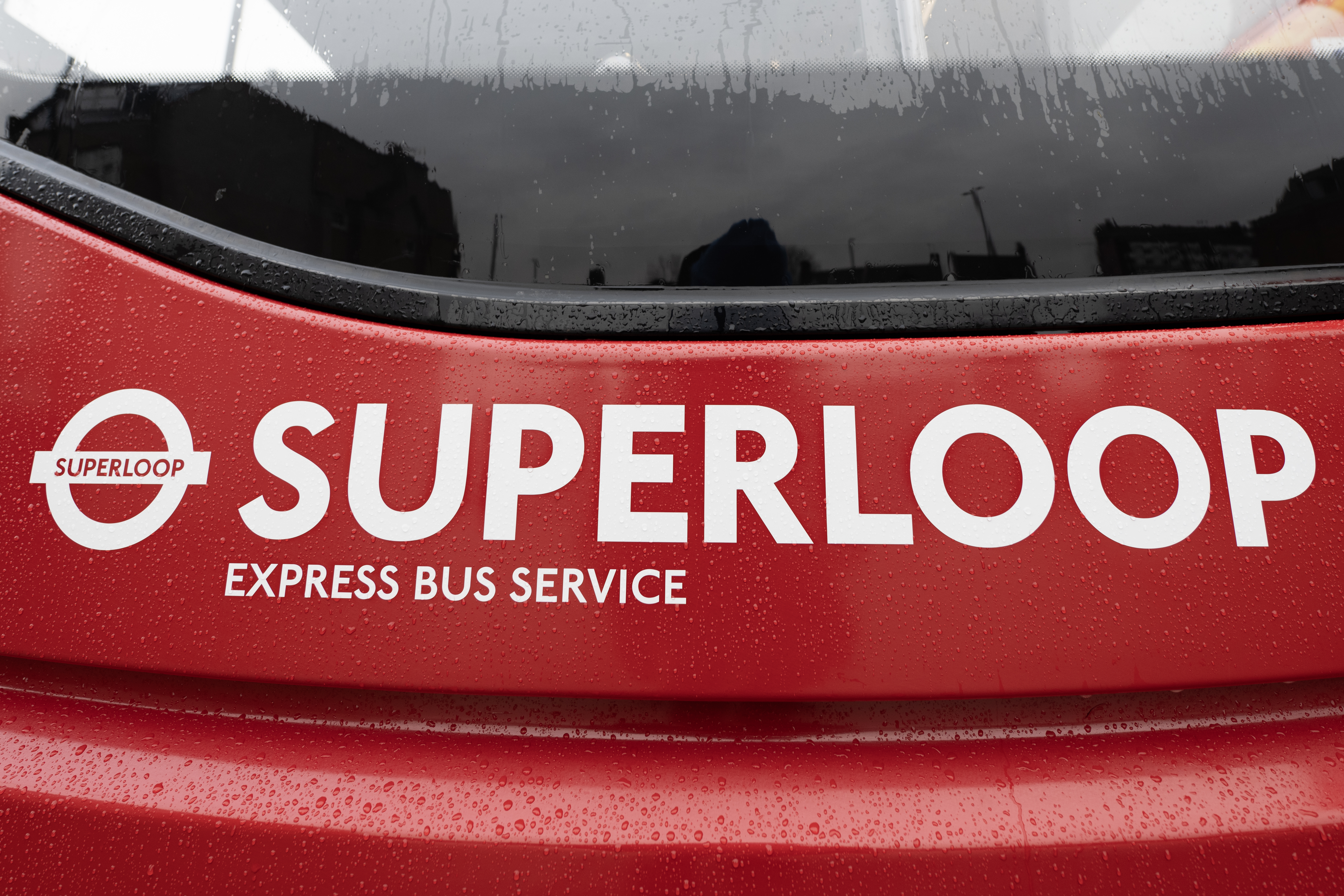 SUPERLOOP Express Bus Service branding and circular SUPERLOOP logo on a bus