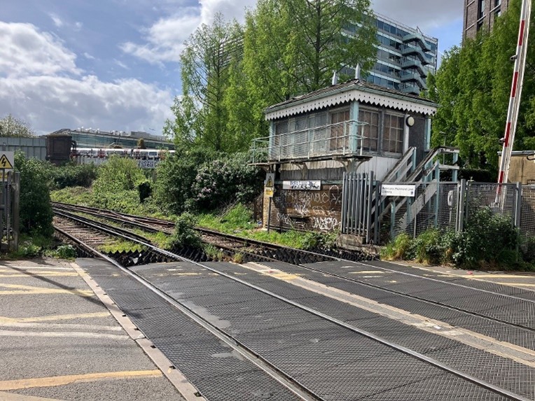 A photograph of the Mildmay line level crossing and signal box at Bollo Lane