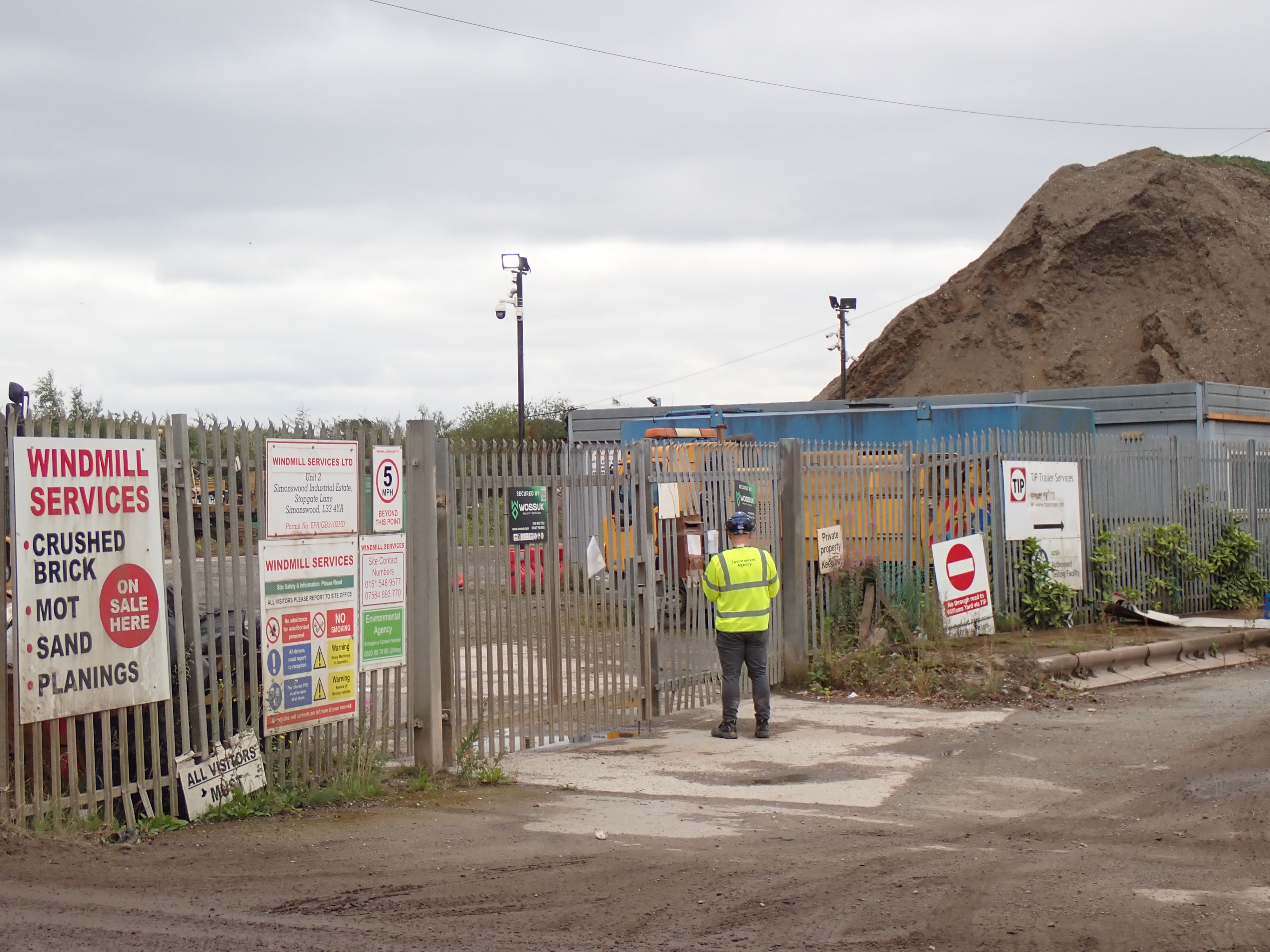 EA Officer in high-viz EA Branded PPE outside the gates at Windmill Services