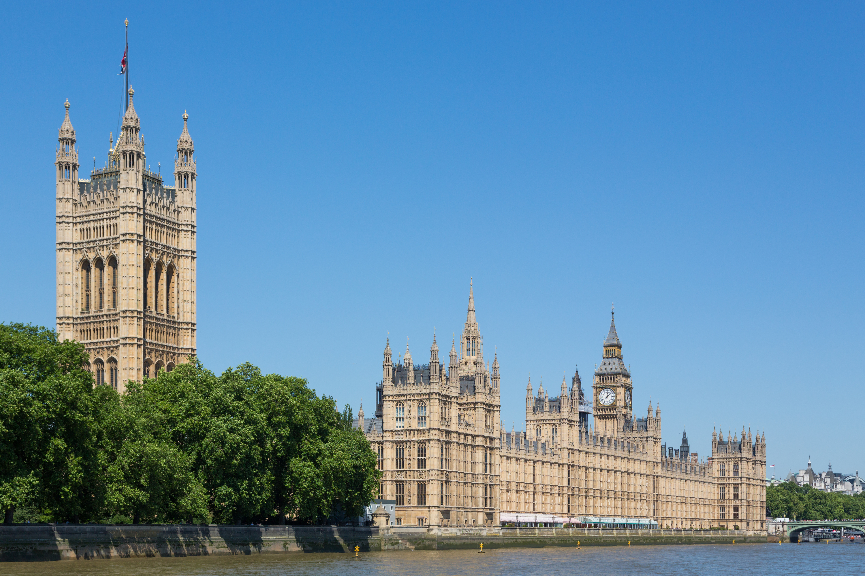 Houses of Parliament and Big Ben beside the River Thames under a clear blue sky