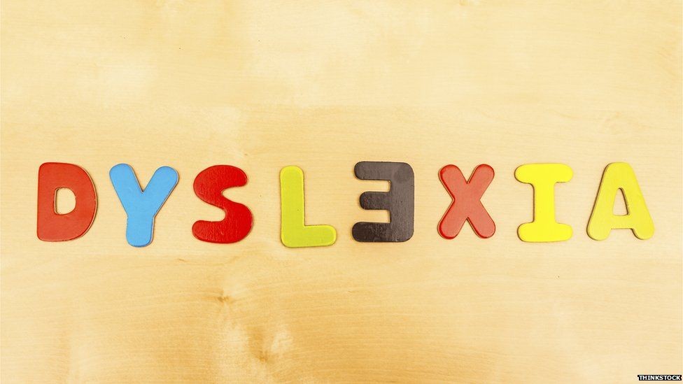 A 'wood' effect background with the word 'dyslexia' in red, blue, yellow and black letters. The letter 'E' is reversed.