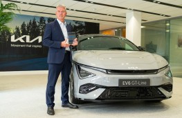 Paul Philpott, president and CEO of Kia UK, 2024, with Kia EV6