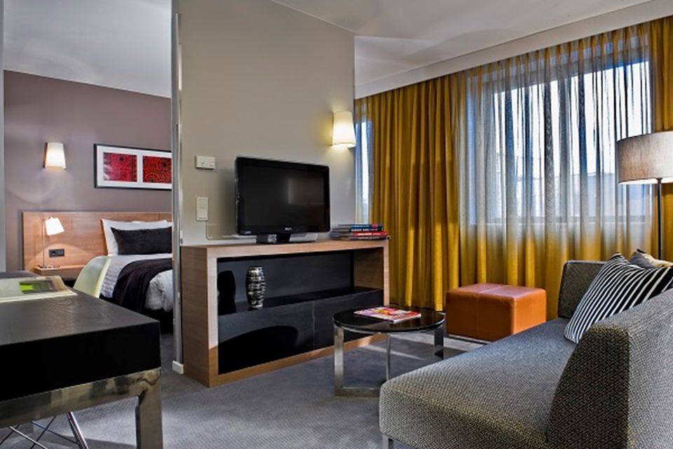 Serviced Apartment, Schlafzimmer 1 mit Holzbett und Nachttischleuchten in Berlin Mitte